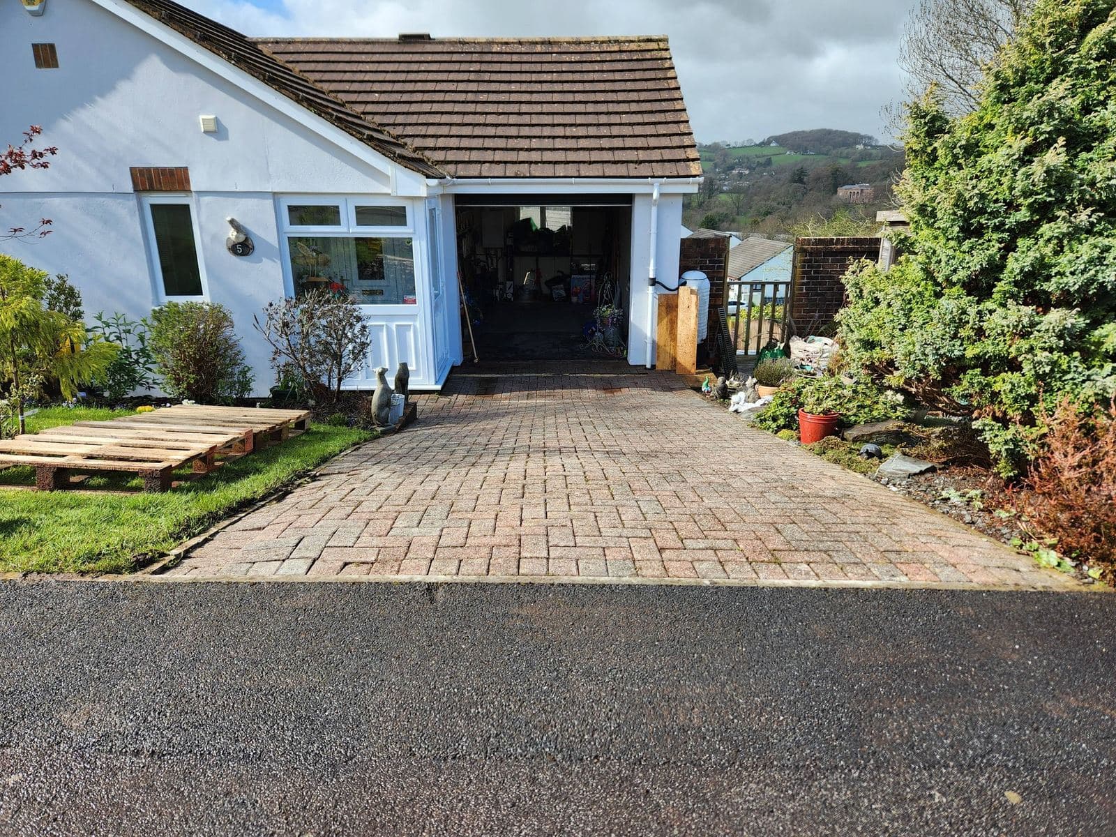 Driveway after — fresh block paving leading up to a blue bungalow