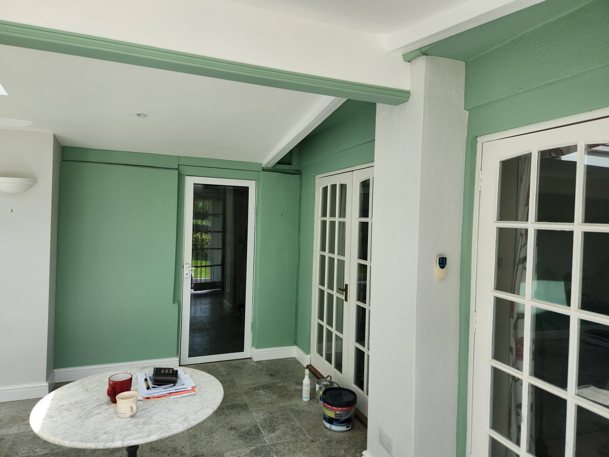 Conservatory after — sage green throughout with white trim